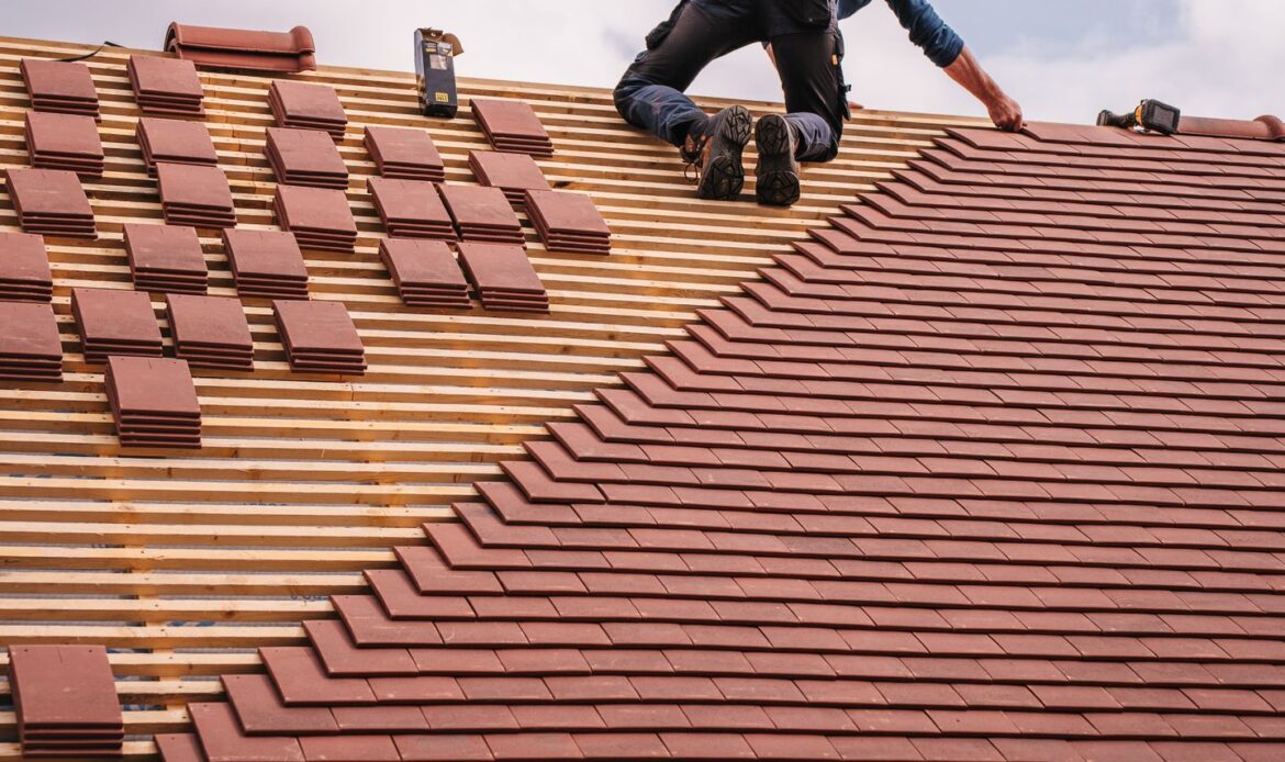 Roofer installing new shingles during a residential roof replacement